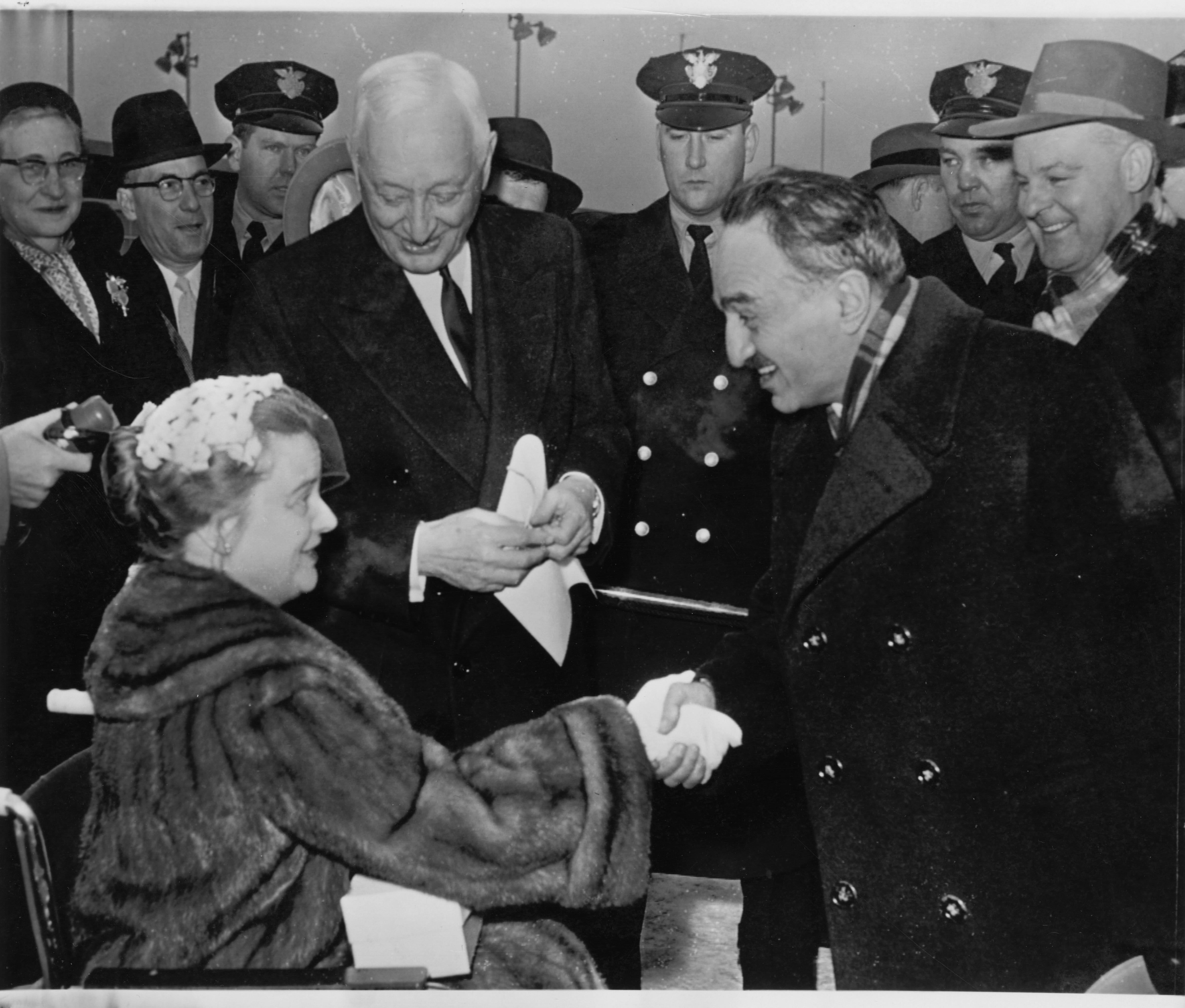 Anastas Mikoyan (right) meets Cyrus Eaton (standing) and his wife, Anne (seated in a wheelchair) upon his arrival in Cleveland, 7 January 1959.