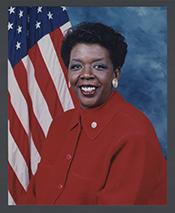 Stephanie Tubbs Jones in a red shirt, sitting in front of an American flag.