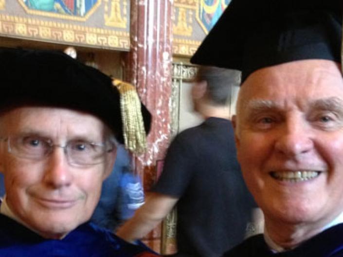 Two professors standing during graduation.