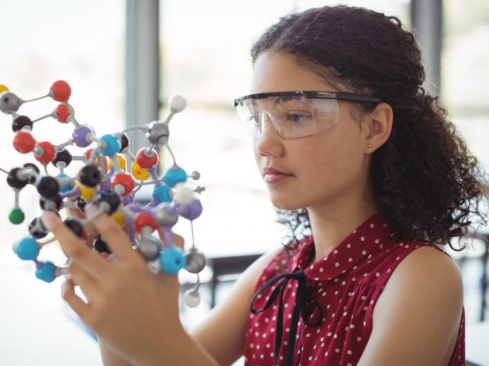 A young girl holding a molecule diorama