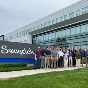 Andrew Ausse with group next to Swagelok sign