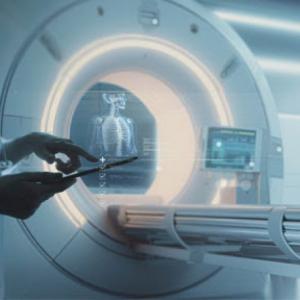 Person holding tablet device in front of MRI machine