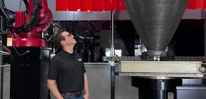 student looking up at a big engineering instrument