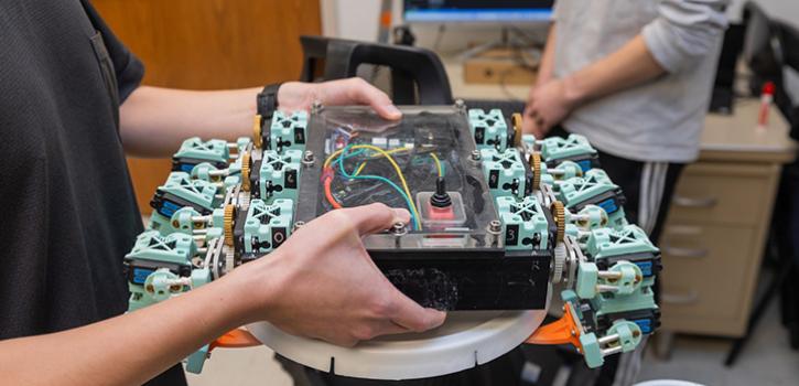 hands holding a piece of robots