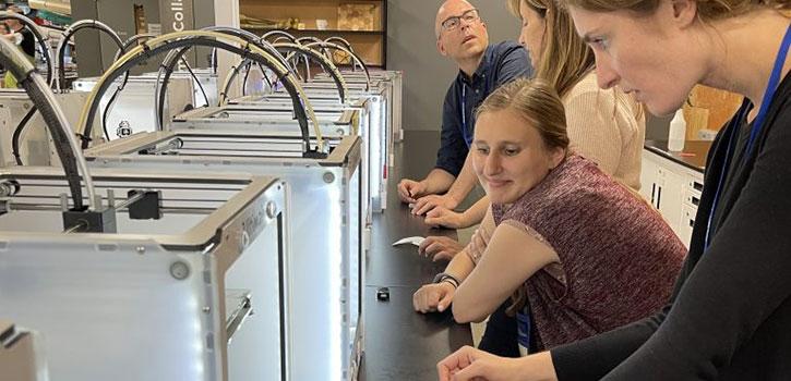 Professor with elementary school student looking at a metal box