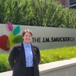 Kat Menstell standing in front of J.M. Smucker Company sign