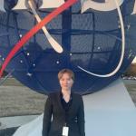 Teagan Smith standing in front of NASA sphere