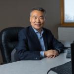 Shuo Li sitting in front of a computer