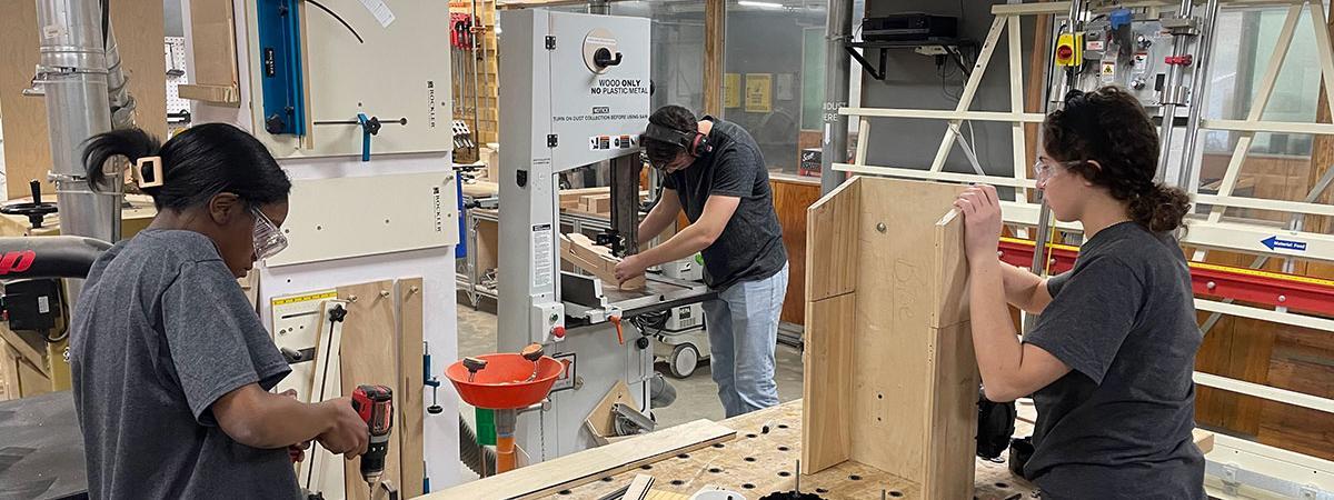 High school students using tools to woodwork
