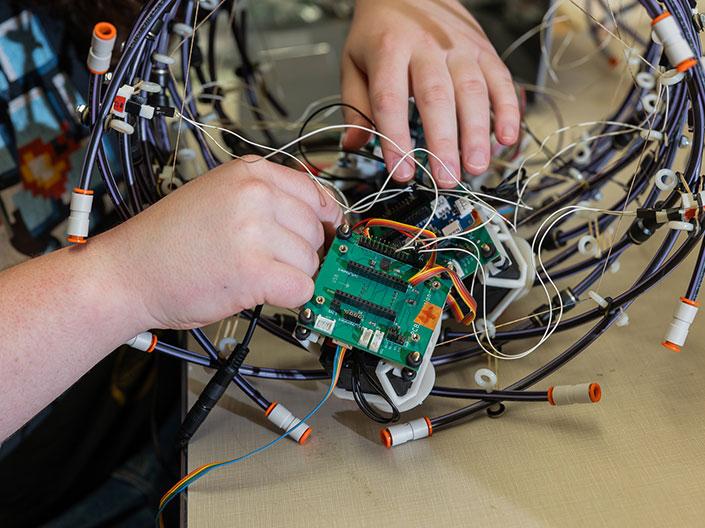 hands working on a piece of mechanical engineering equipment