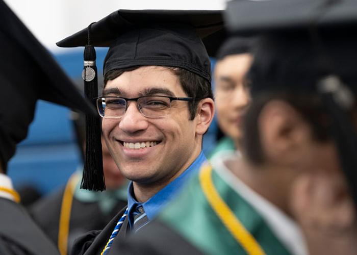 person in cap and gown smiling
