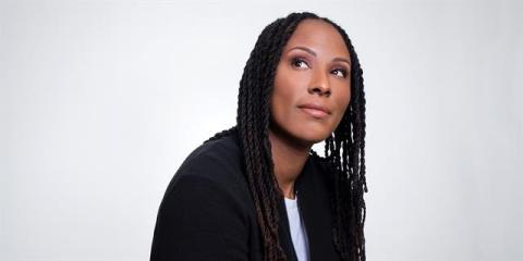 Headshot of Chamique Holdsclaw. She is wearing a black shirt looking away from the camera