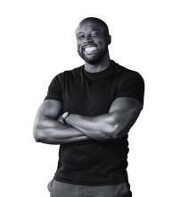Picture of Kwame Christian smiling in black in white