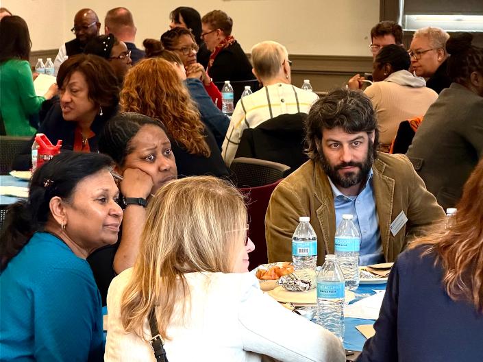 A group of people sitting at tables during an event.