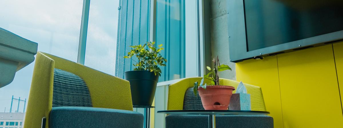 A photo of two chairs and a tv monitor in front of a window
