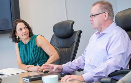Two employees of Case Western Reserve University seated, discussing technology transfer at a meeting