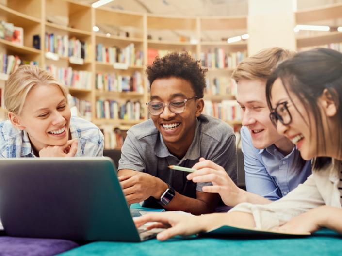 Group of students gathered around laptop