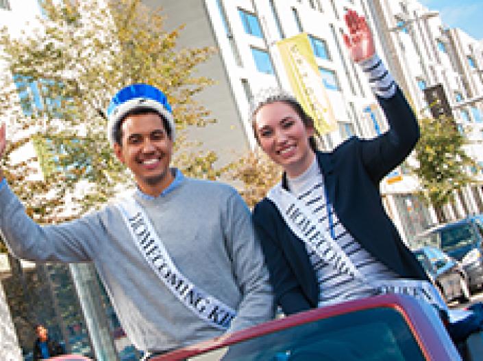 Case Western Reserve University homecoming king and queen riding in a car in the parade
