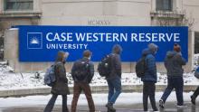 Students walk in front of Case Western Reserve University signage located near Allen Memorial Medical Library