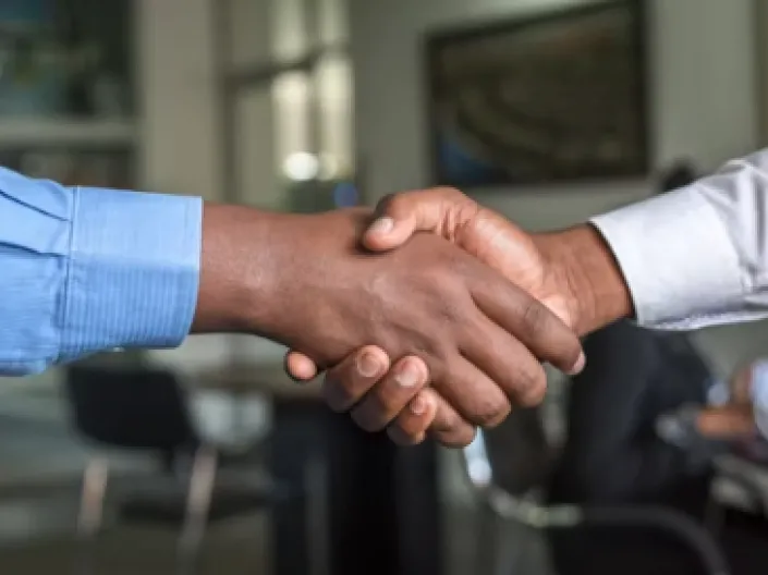 Office handshake between two individuals.