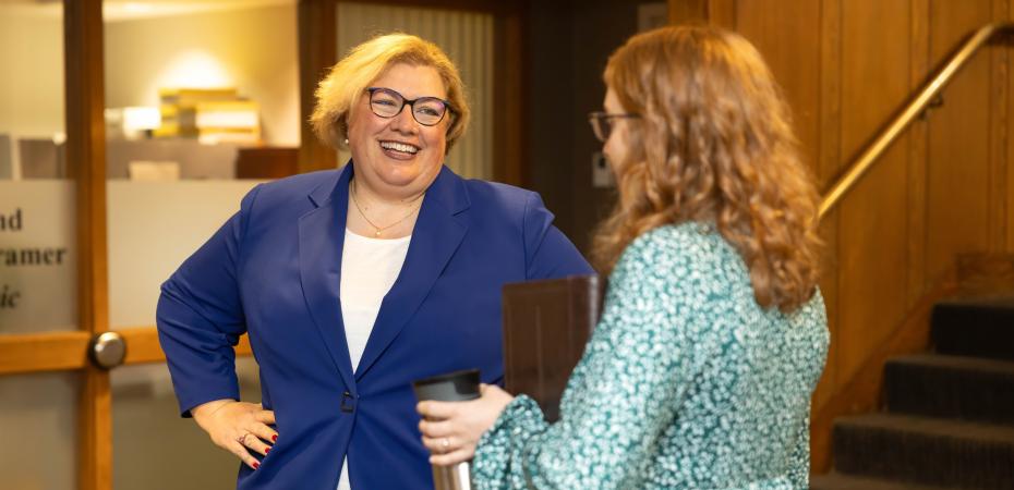 Two women smiling and talking.