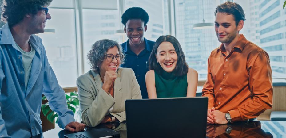 A group of people networking around a computer.