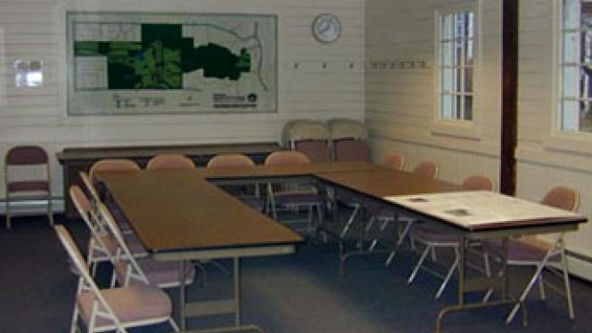 View of CWRU Kutina Classroom, with tables and folding chairs, and a map on the far wall