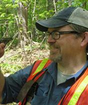 Dr. Michael Benard holding an amphibian in the woods