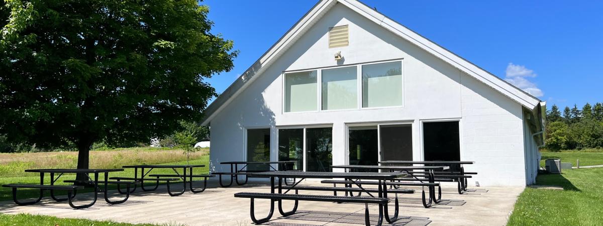Exterior of November Meeting Center rear with patio and tables