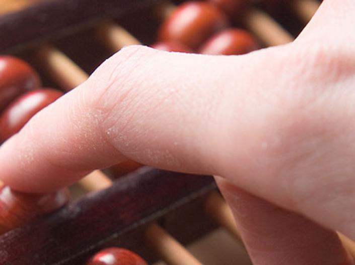Image of hand on abacus 