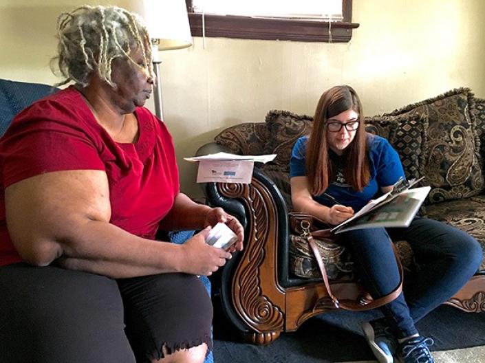 Social work student meeting with a resident in a living room