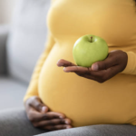 Pregnant woman holding an apple