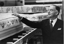 Black and white photo of Ernest Wuliger touching a mattress