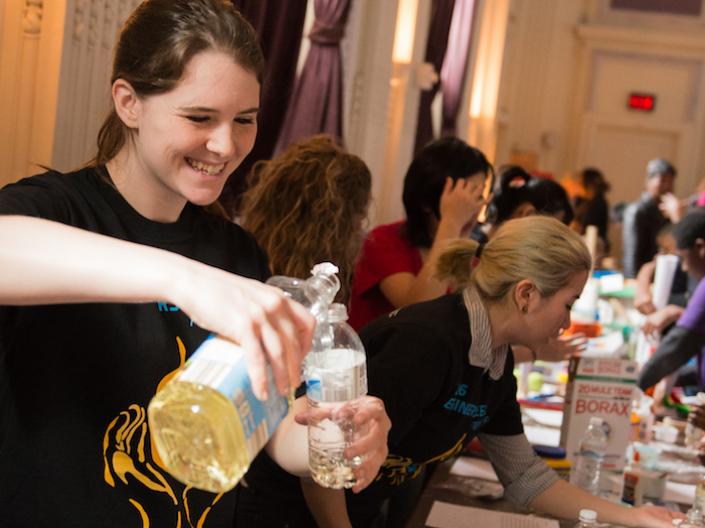 Group of youth and adults at a table working on science experiments