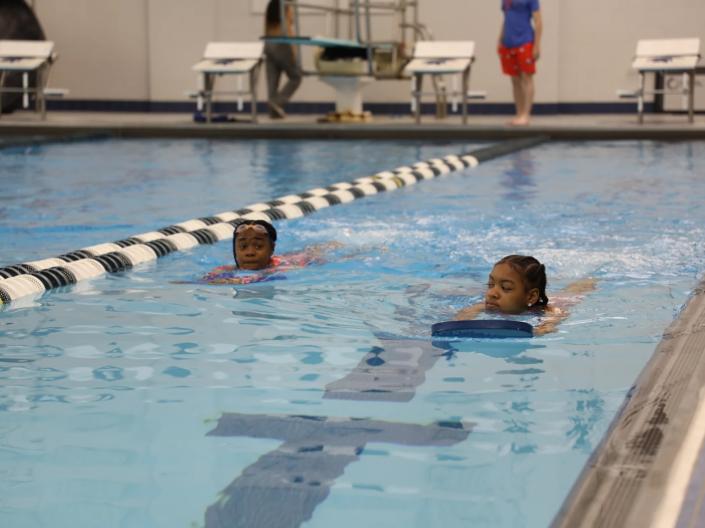 two girls swimming laps in a pool