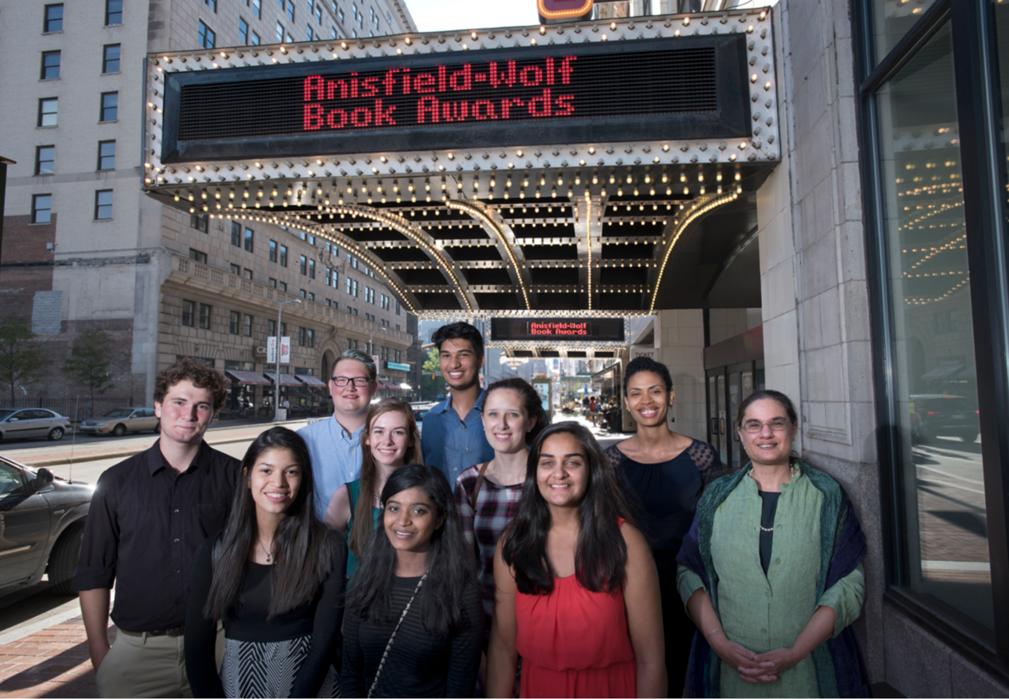 Students and Faculty member in front of marquee sign