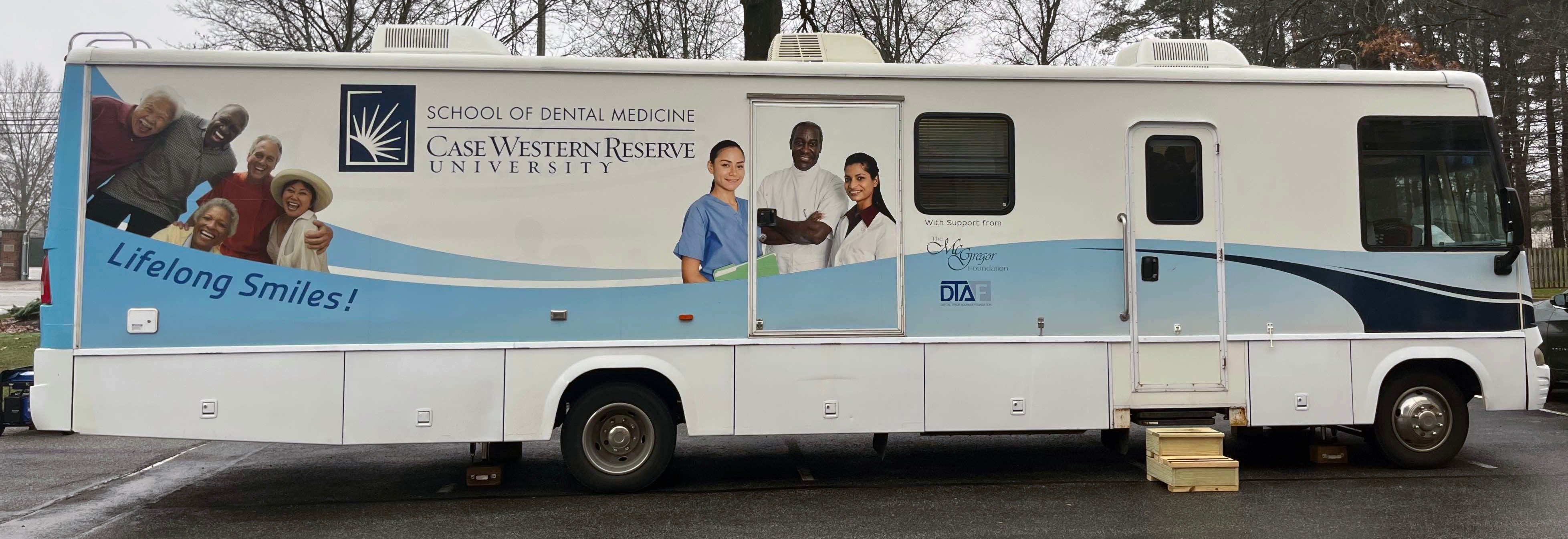 The parked dental care RV with the CWRU School of Dental Medicine logo and the words "lifelong smiles"