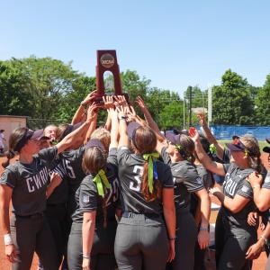 Case Western Reserve softball team huddles and holds NCAA Super Regional trophy up in the middle of the group