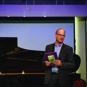Gary Von Lehmden speaks on stage while wearing formal attire.