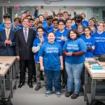 A group of CWRU students in a classroom wearing t shirts that read "Thank you Roger Susi!"