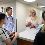 Four people talking at the CWRU Student-Run Health Clinic