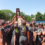 Case Western Reserve softball team huddles and holds NCAA Super Regional trophy up in the middle of the group