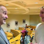 Victor Flatt and Maggie Kaniecki speak with each other in a law school lecture hall