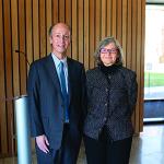 Kevin Kranzusch and Lynne Bosworth smile at camera in front of a podium in Olin Hall while wearing formal attire