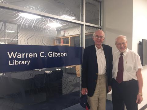 Warren Gibson and Adel “Tony” Saada smile at the camera in front of the Warren C. Gibson Library