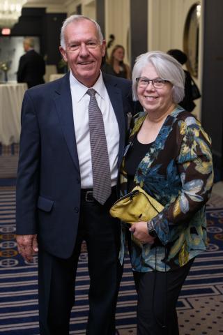 David (WRC ’75, DEN ’79) and Susan Mills smile at camera while wearing formal attire at an event