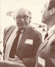 Jack Caughey speaks to someone next to him while wearing formal attire