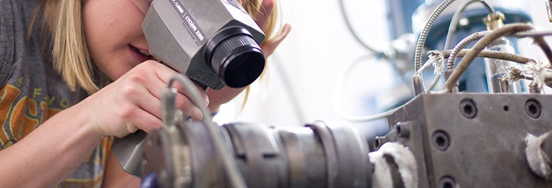 Student in research examining equipment