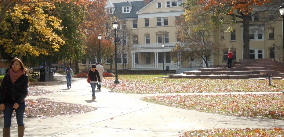 Students walking on Mather Quad in Autumn past Guilford Hall