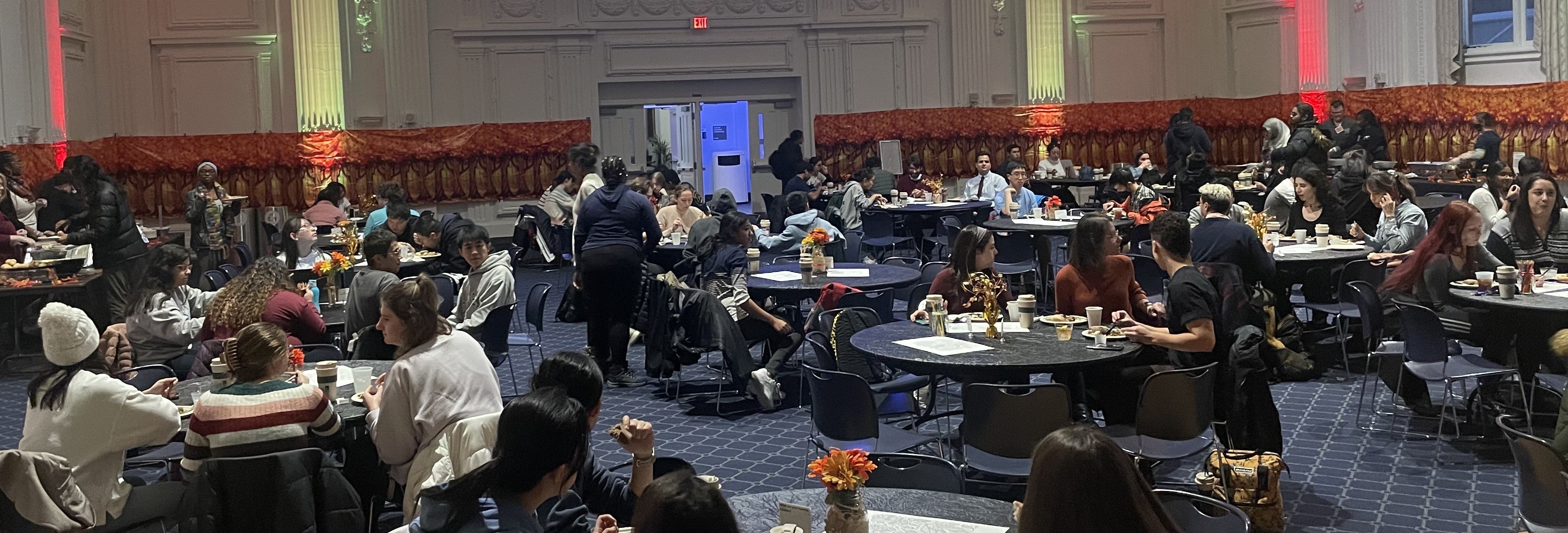 Dozens of graduate students eating a feast in Thwing Center Ballroom